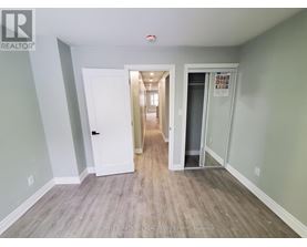 A hallway with a white door and a glass door leading to another room.