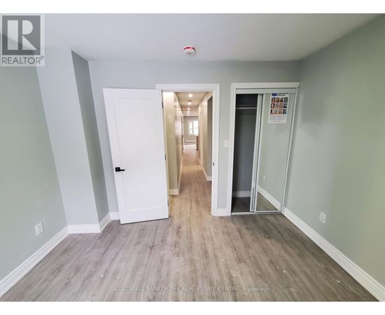A hallway with a white door and a glass door leading to another room.