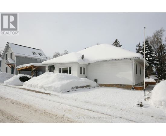 A house with a snow-covered roof and driveway.