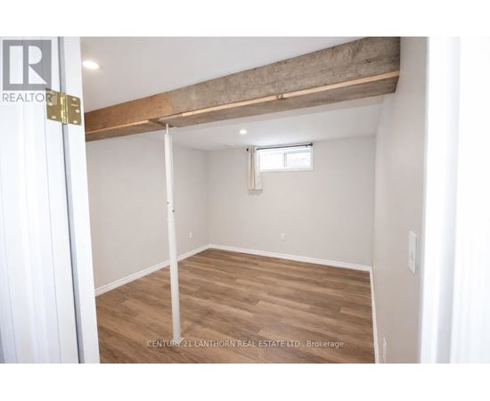 A room with a window and a wooden beam on the ceiling.