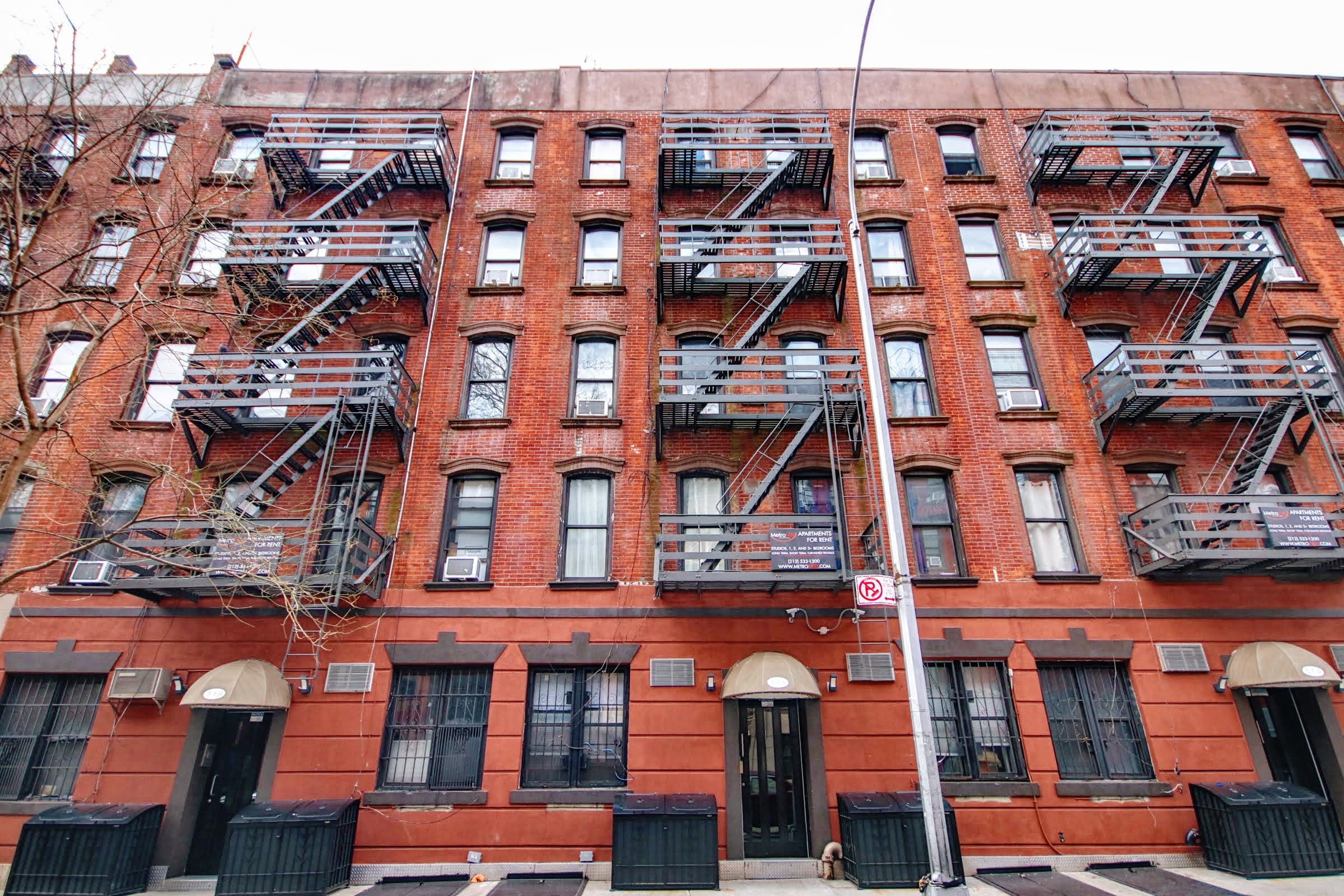 a red brick apartment building with fire escapes