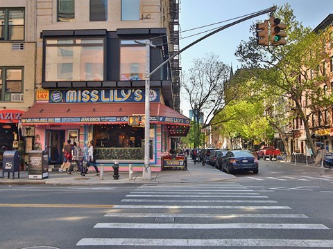 a busy city street with a crosswalk in front of a restaurant