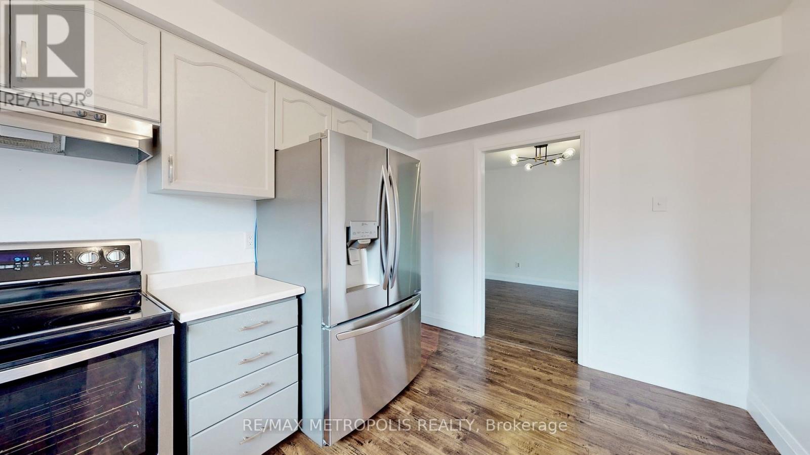 A kitchen with a black stove top oven and white cabinets.