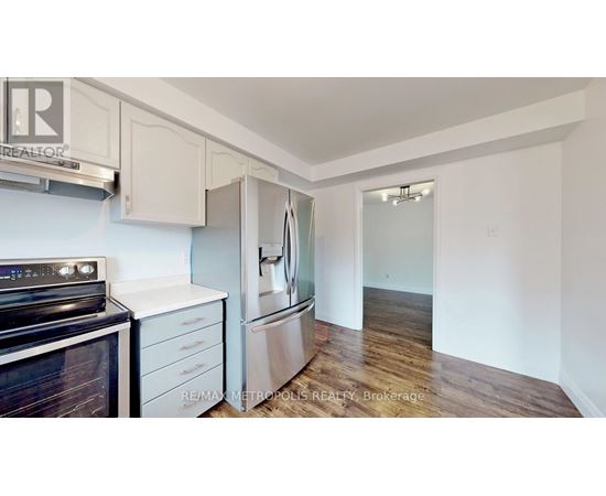 A kitchen with a black stove top oven and white cabinets.