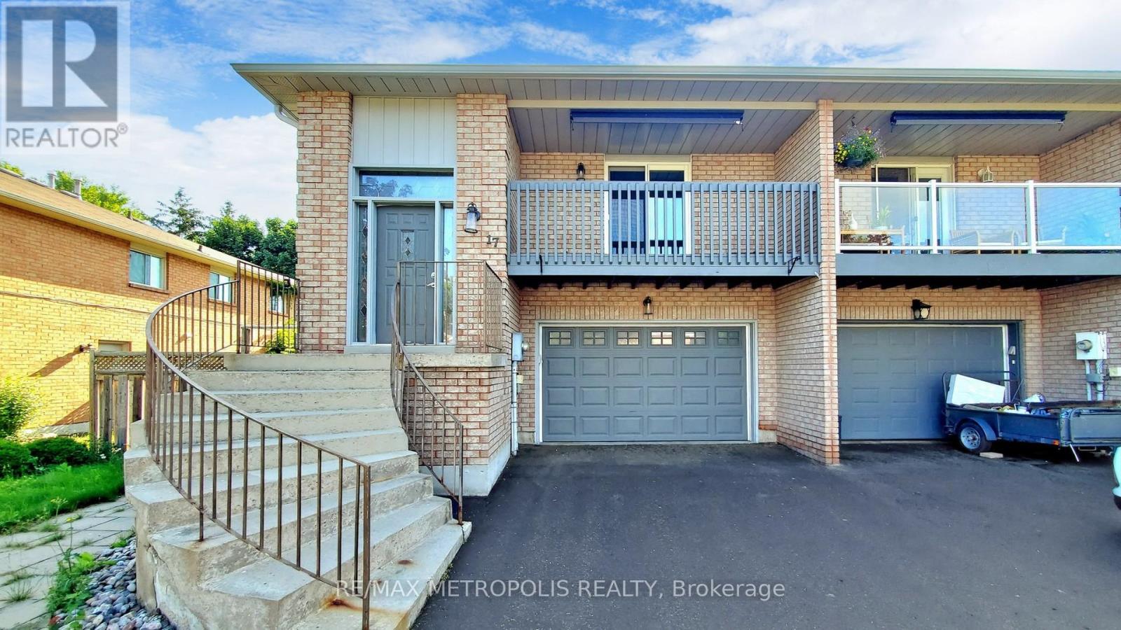 A two-story brick house with a balcony and a garage.