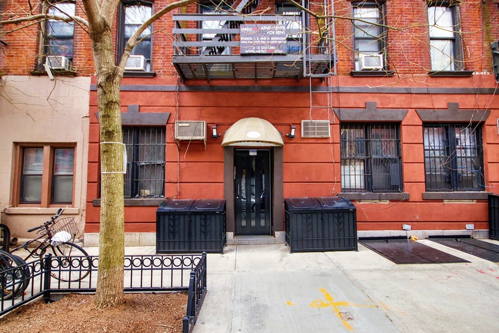 the front of a red brick building with a black door