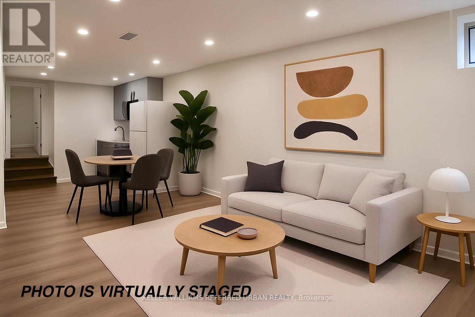 A living room with a couch, coffee table, and a painting on the wall.