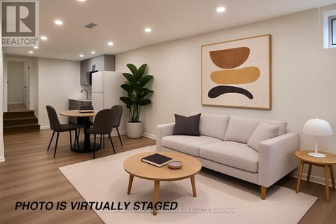 A living room with a couch, coffee table, and a painting on the wall.