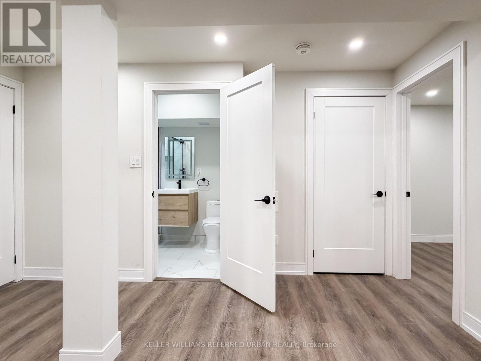 A spacious hallway with doors on both sides and a light on the ceiling.
