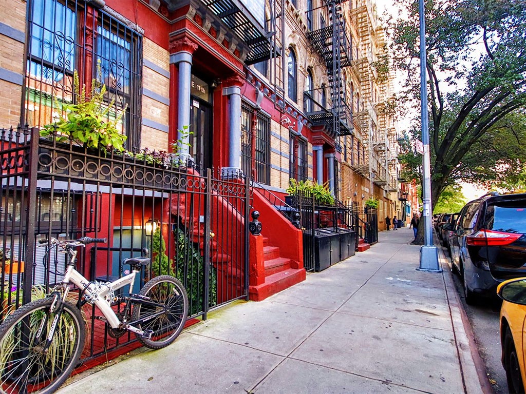 a bicycle parked on a sidewalk in front of a red building