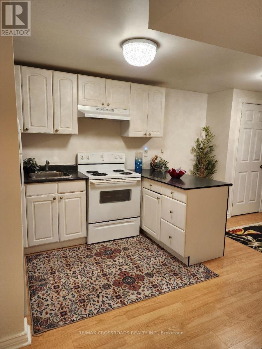 A kitchen with white cabinets and a white stove top oven.