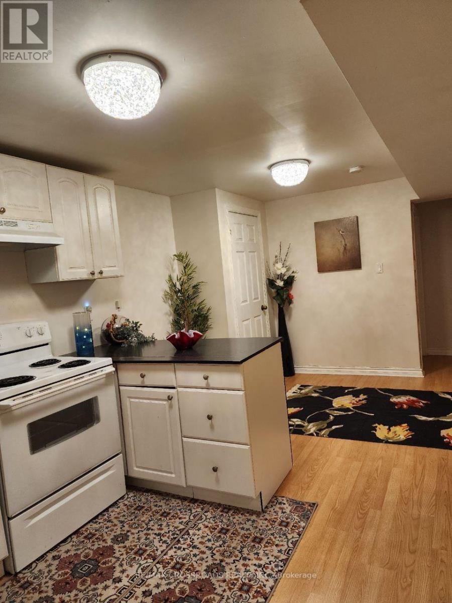 A kitchen with a white stove and cabinets.