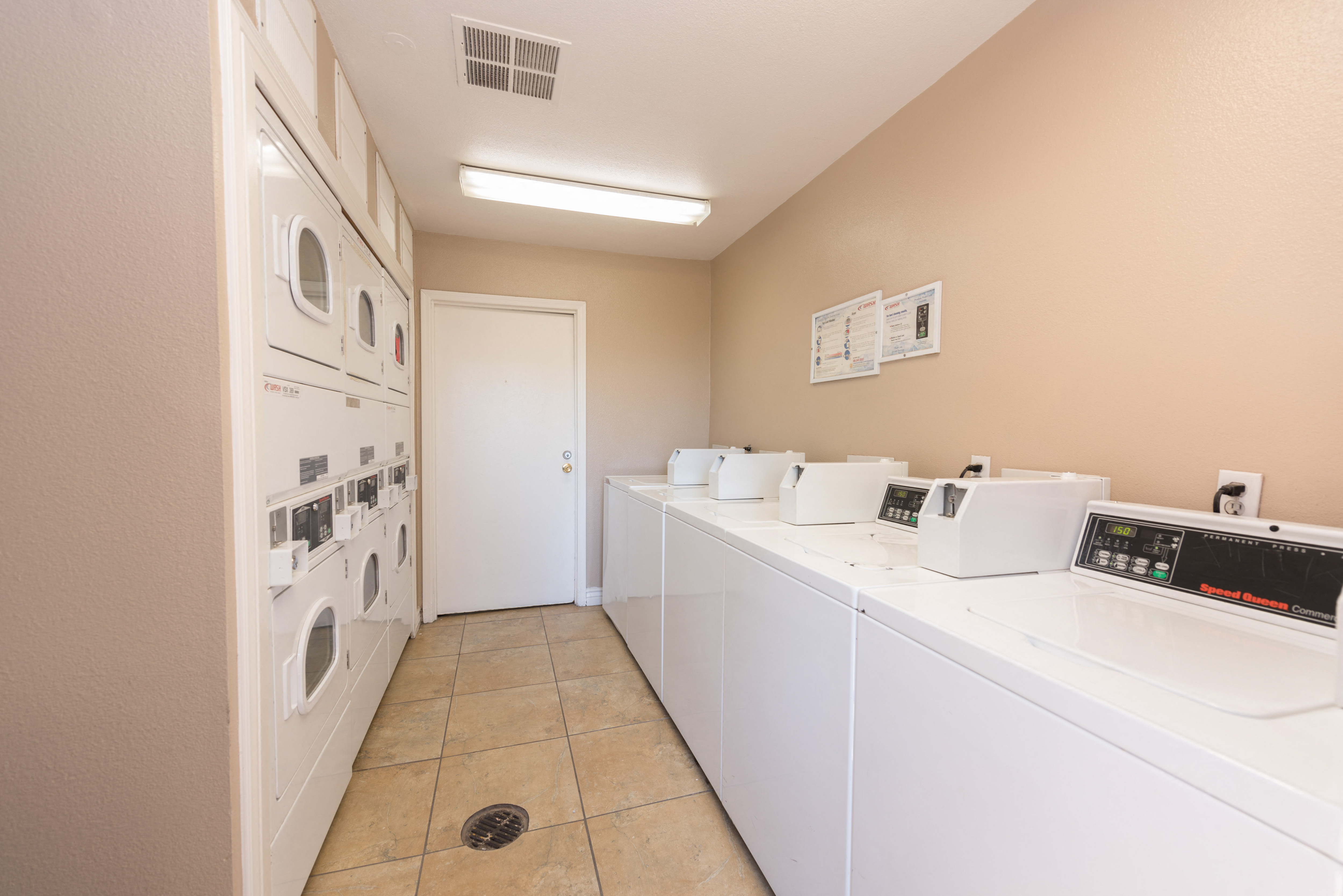 a laundry room with washes and dryers and a door to a laundry closet