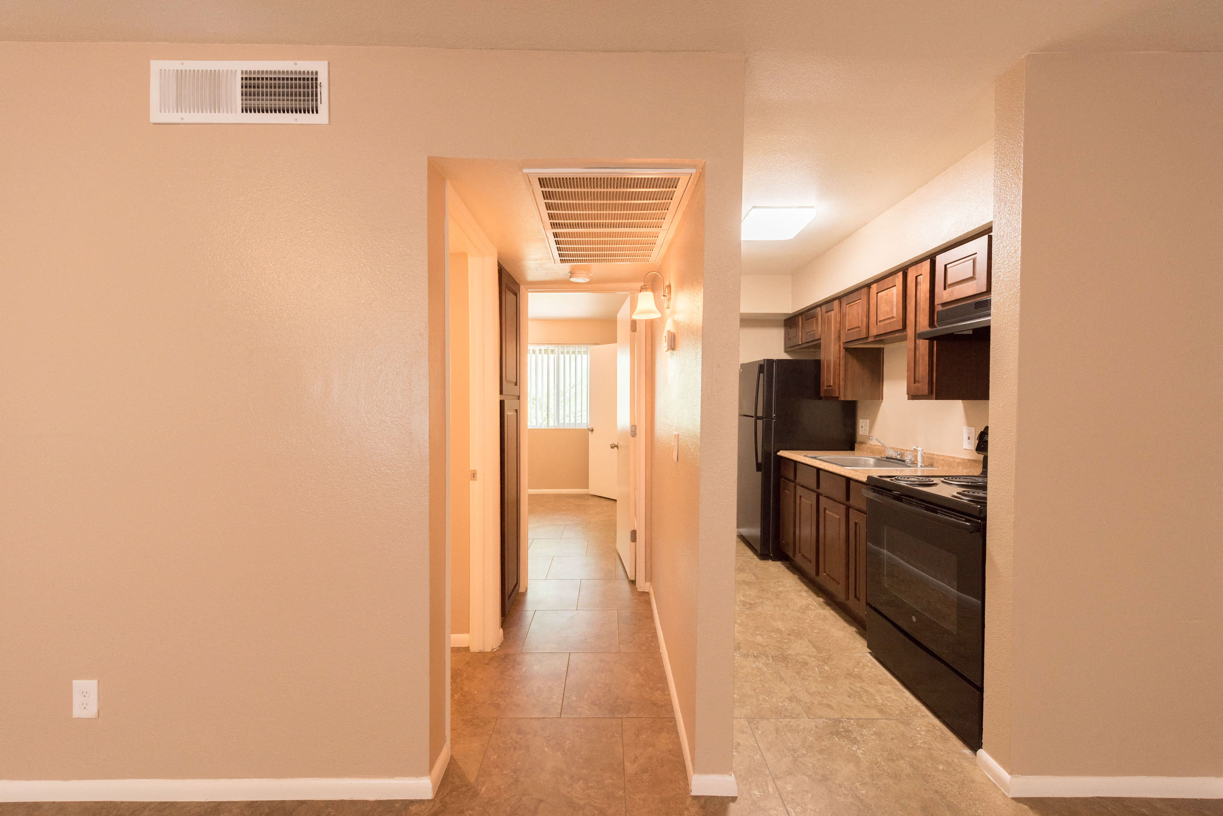 a view of a kitchen and a hallway with a door to a living room