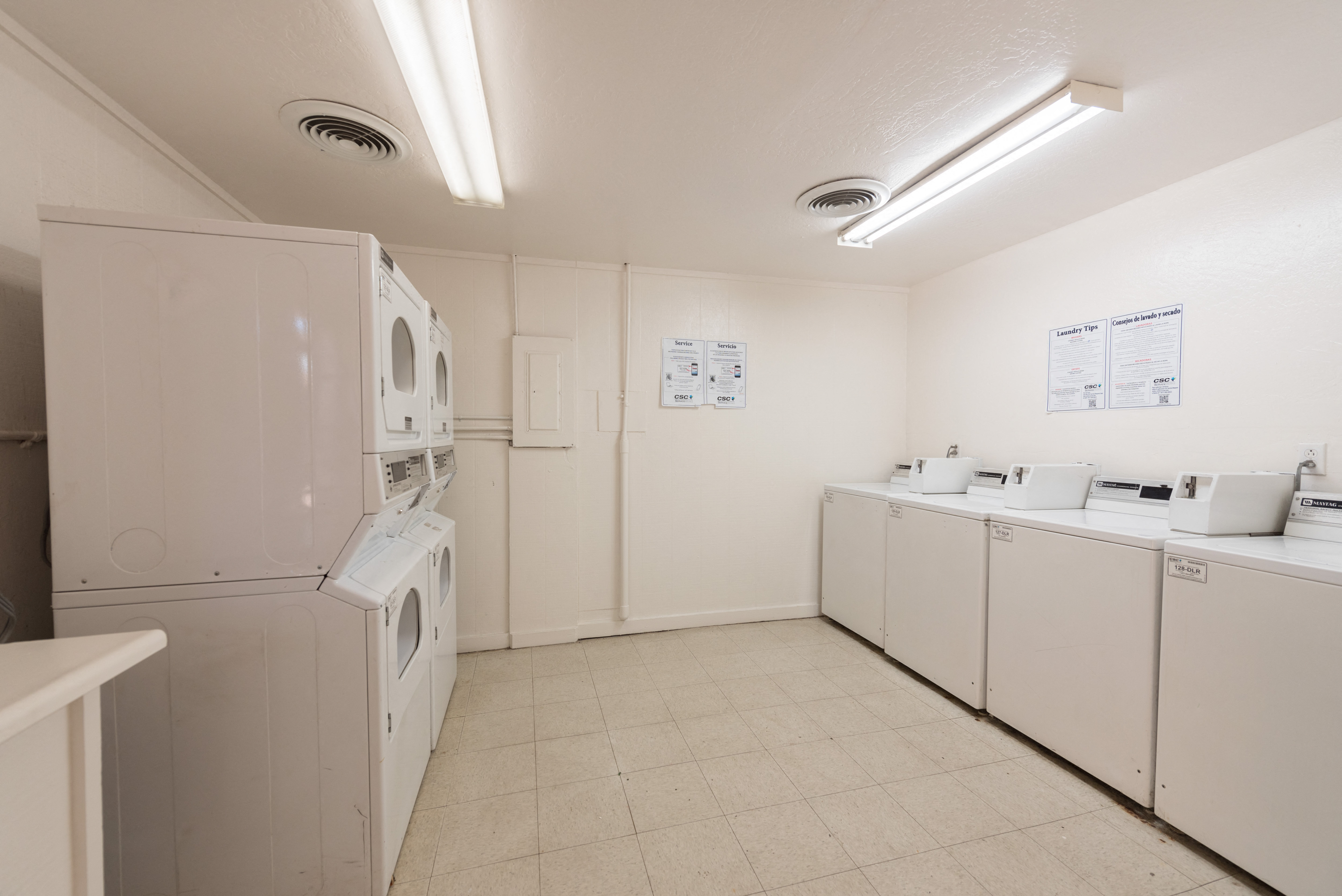 a laundry room with washer and dryers and sinks and a washing machine