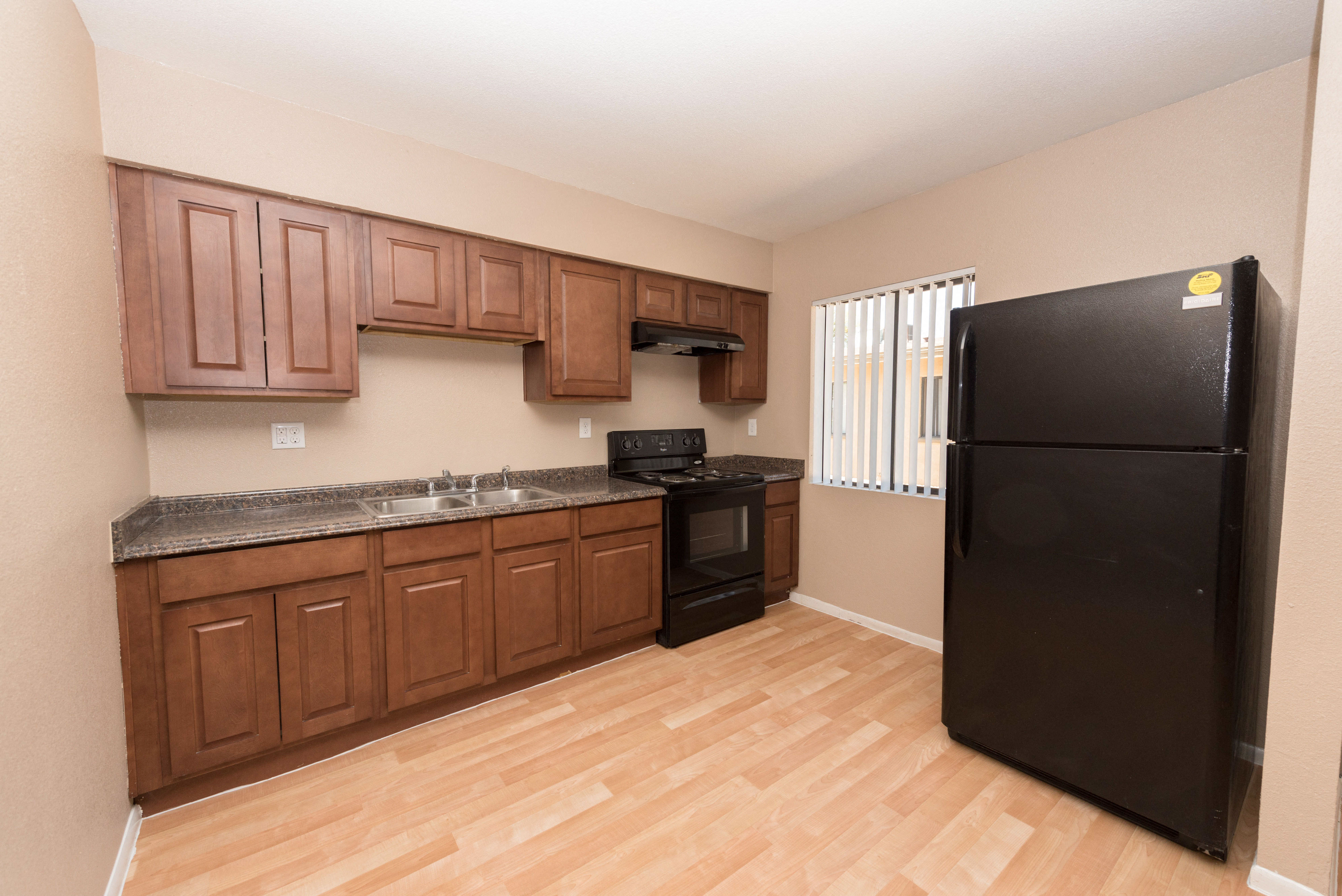 a kitchen with black appliances and wooden cabinets