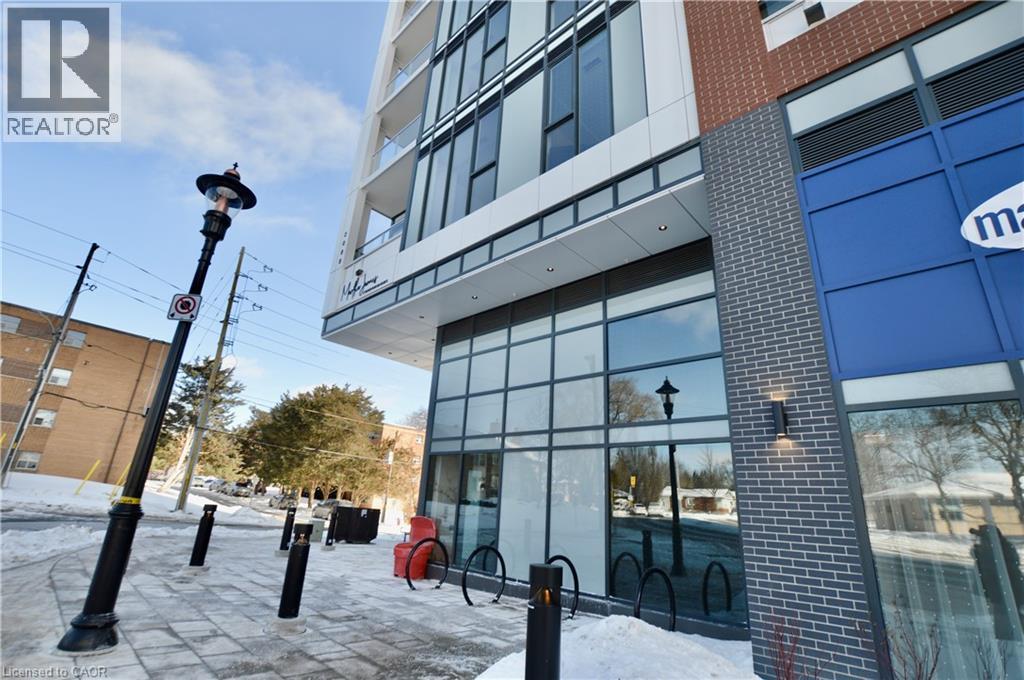 A building with a blue sign on the right side and a red bike rack in front of it.