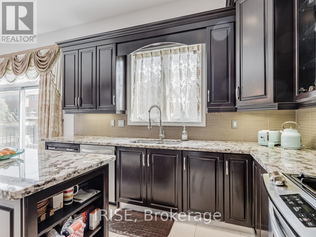 A kitchen with dark brown cabinets and a marble countertop.