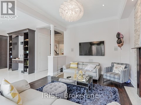 A living room with a white couch and a grey ottoman.