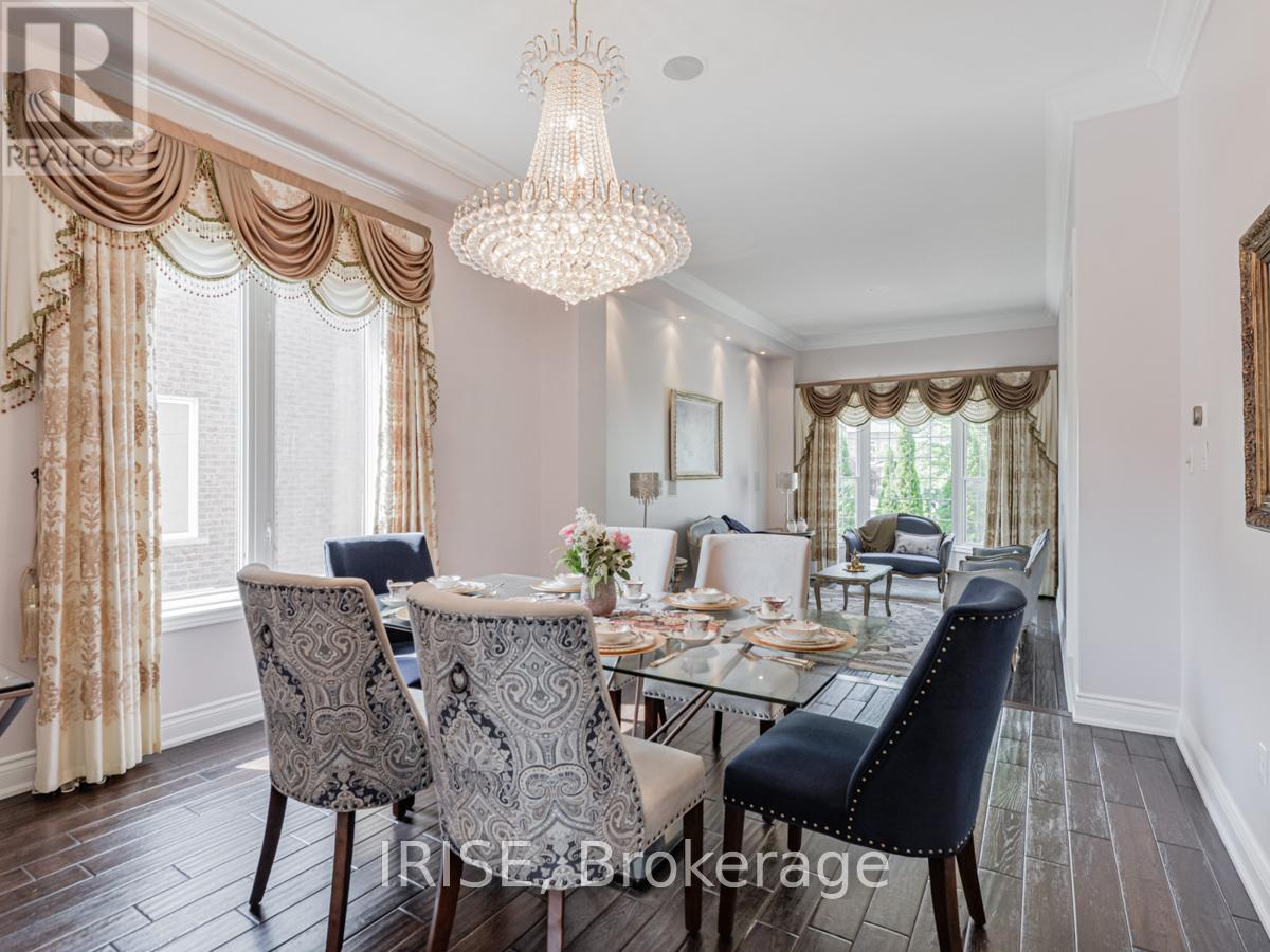 A dining room with a chandelier, a table set for six, and a view of the backyard.