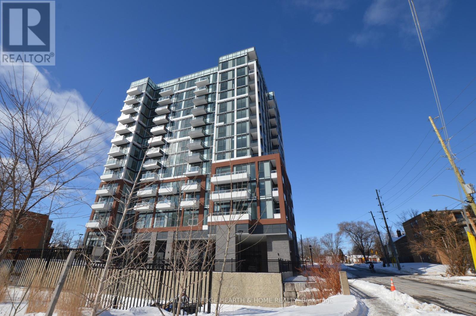 A tall residential building with a fence in front of it.