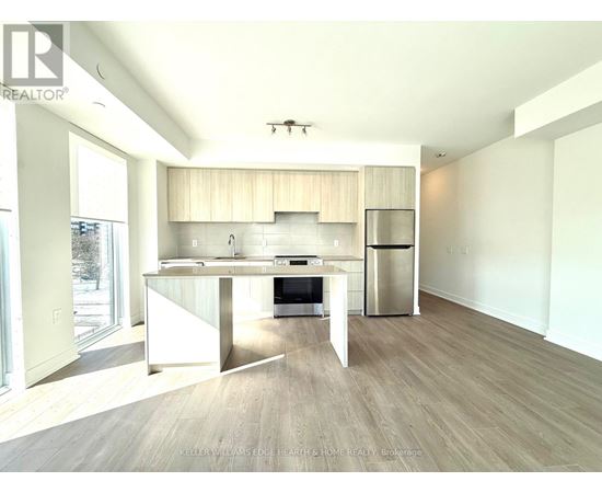 A modern kitchen with a dining table and a refrigerator.