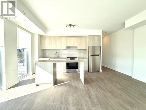 A modern kitchen with a dining table and a refrigerator.