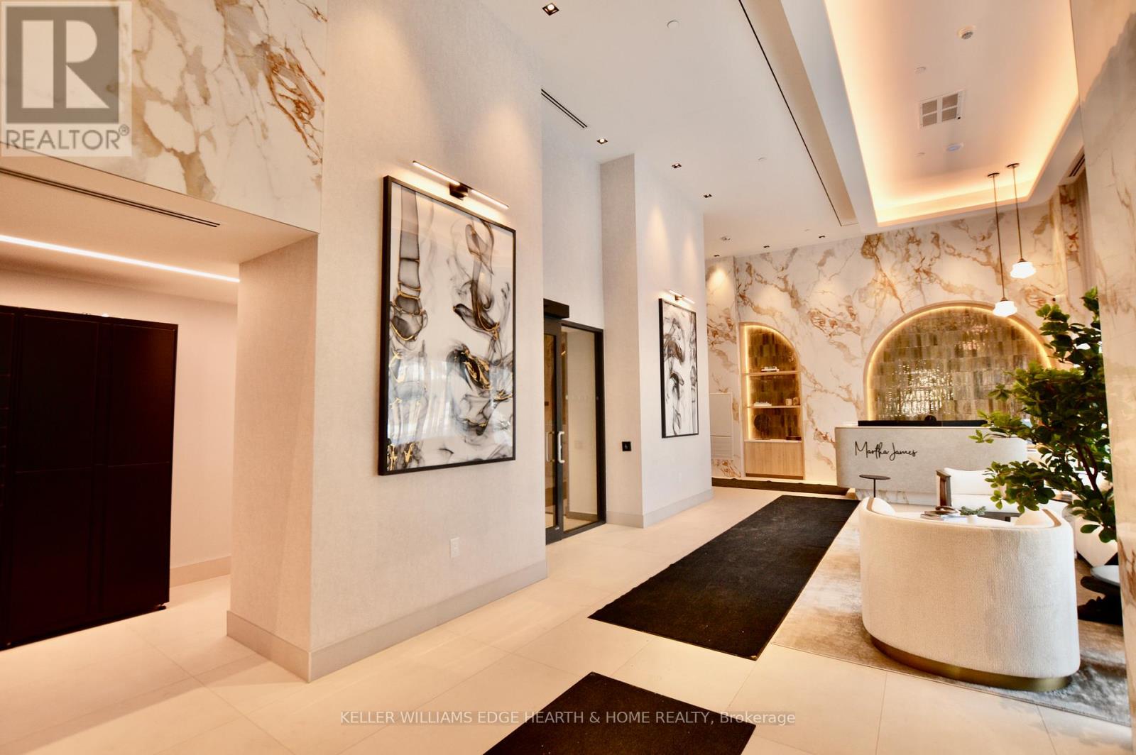 A spacious lobby with a reception desk and a large painting on the wall.