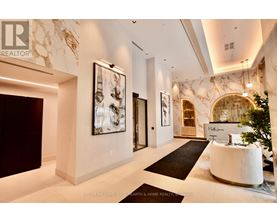 A spacious lobby with a reception desk and a large painting on the wall.