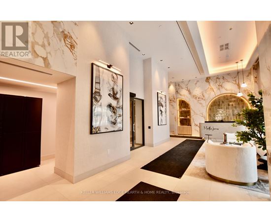 A spacious lobby with a reception desk and a large painting on the wall.