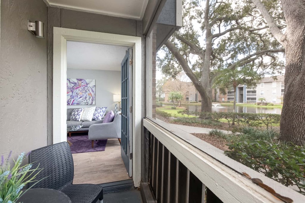 a balcony with a view of a living room and a tree