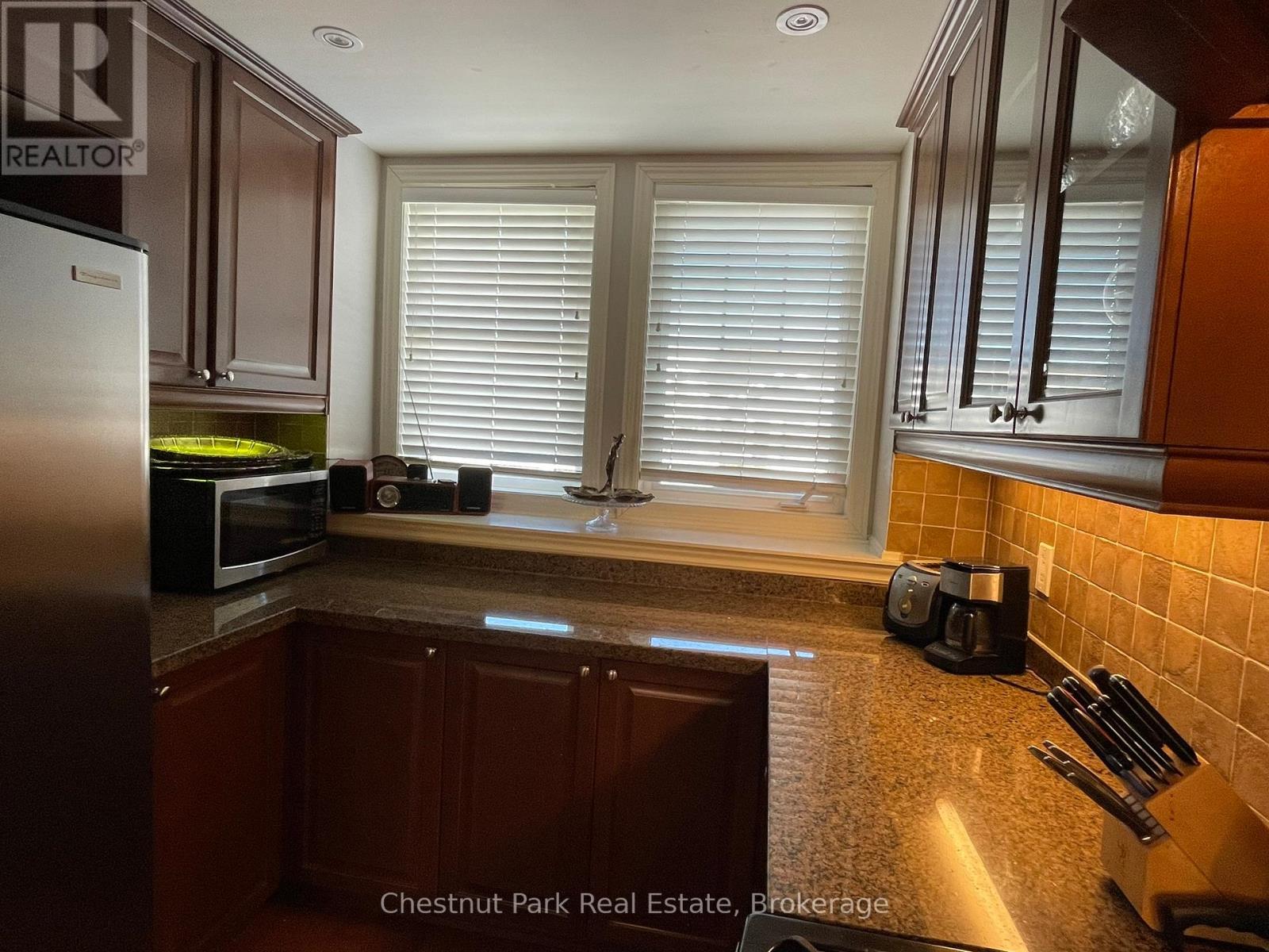 A kitchen with brown cabinets and a refrigerator.