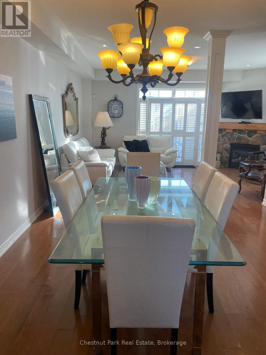 A dining room with a glass table and white chairs.