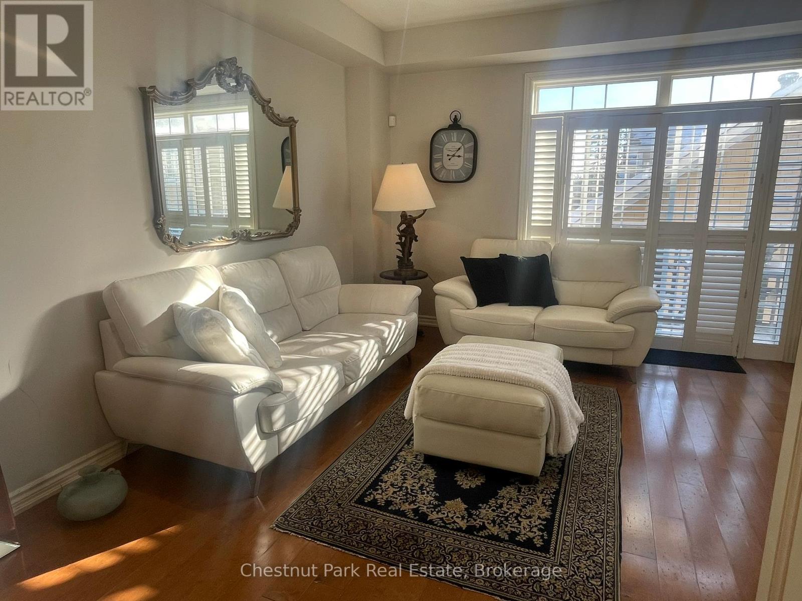 A living room with a white couch and a rug.