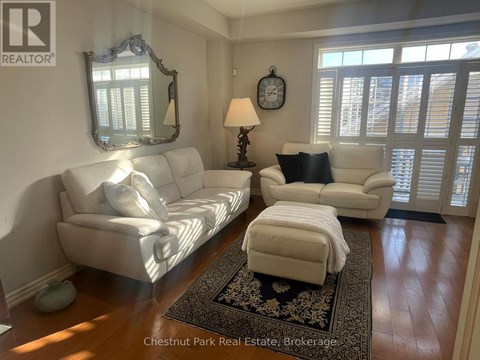 A living room with a white couch and a rug.