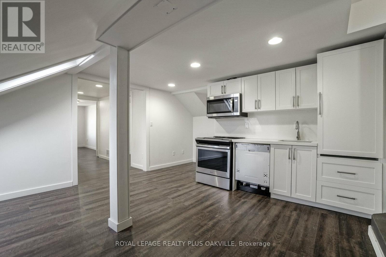 A kitchen with white cabinets and a microwave above the stove.