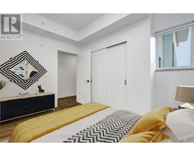 A bedroom with a bed, dresser, and mirror.