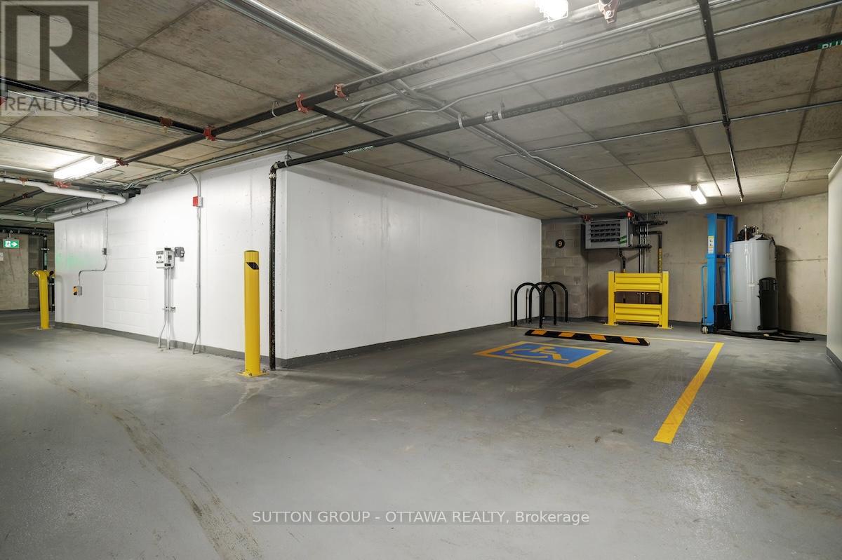 A large, empty warehouse space with a white wall and yellow safety lines on the floor.