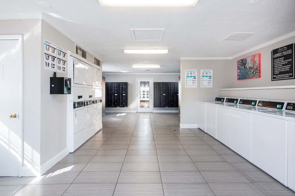 a laundry room with white cabinets and a tile floor