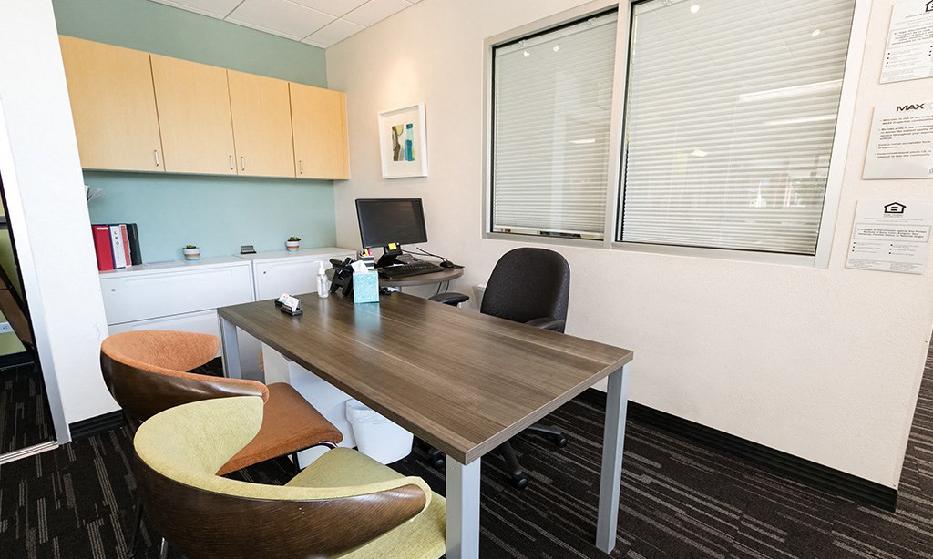 an office with a desk and chairs and a computer