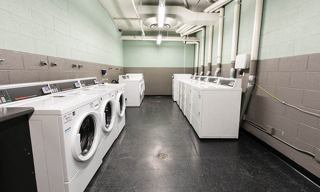 a group of washers and dryers in a laundry room
