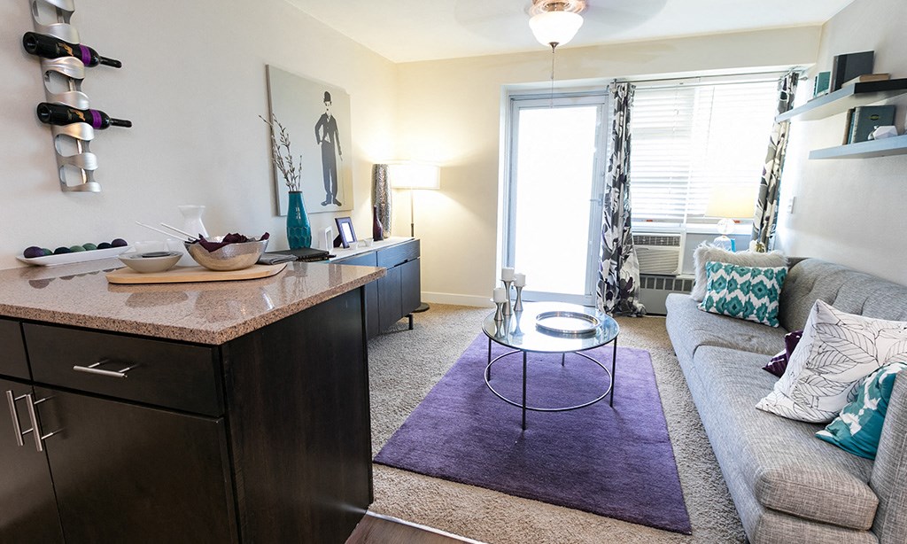a living room with a couch and a table in front of a window