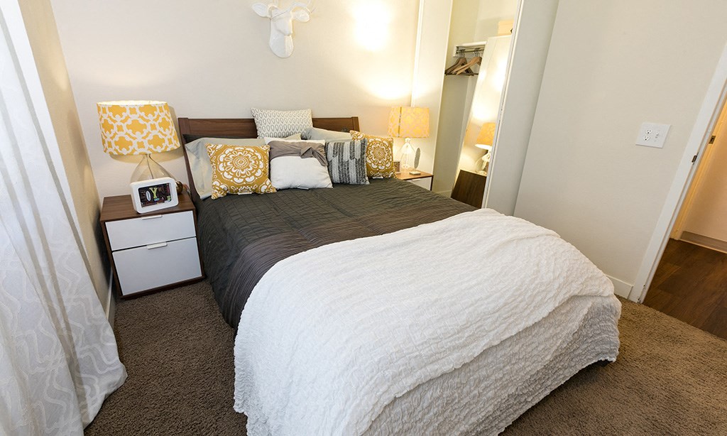 a bedroom with a bed and a nightstand with two lamps