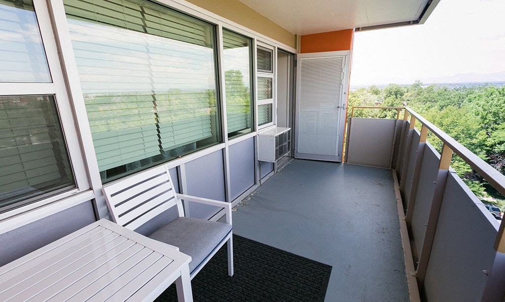 a balcony with a table and a chair and some windows