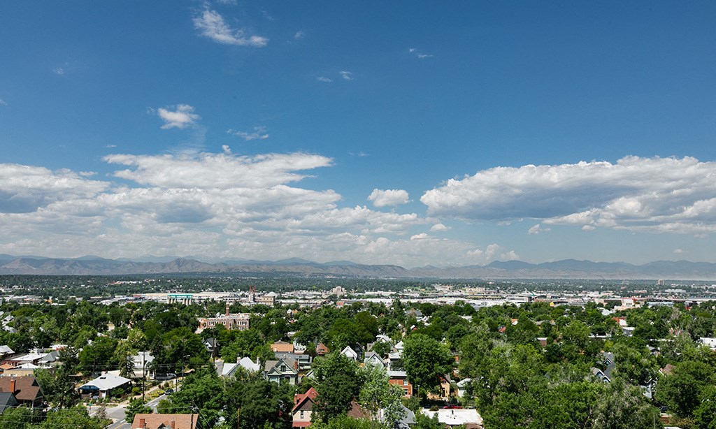 a cityscape of a city with clouds in the sky