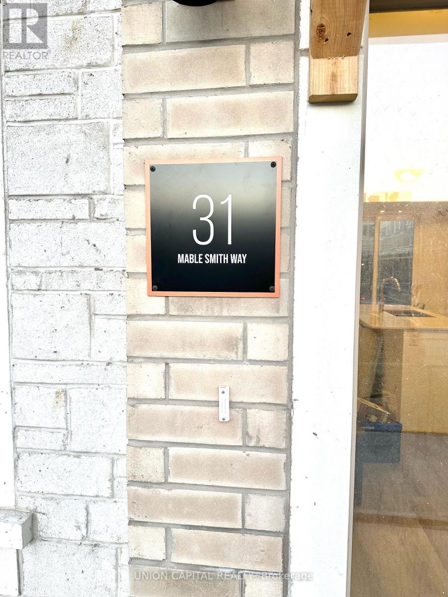 A sign on a brick wall that says 31 Mable Smith Way.