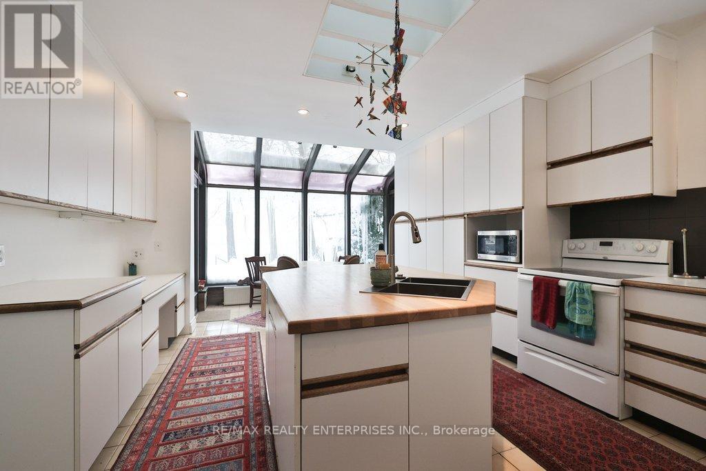 A kitchen with white cabinets and a red rug on the floor.