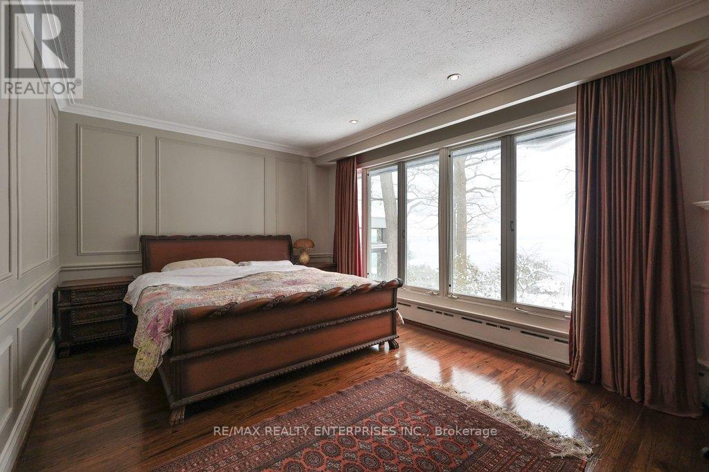 A bedroom with a large bed and a window with curtains.