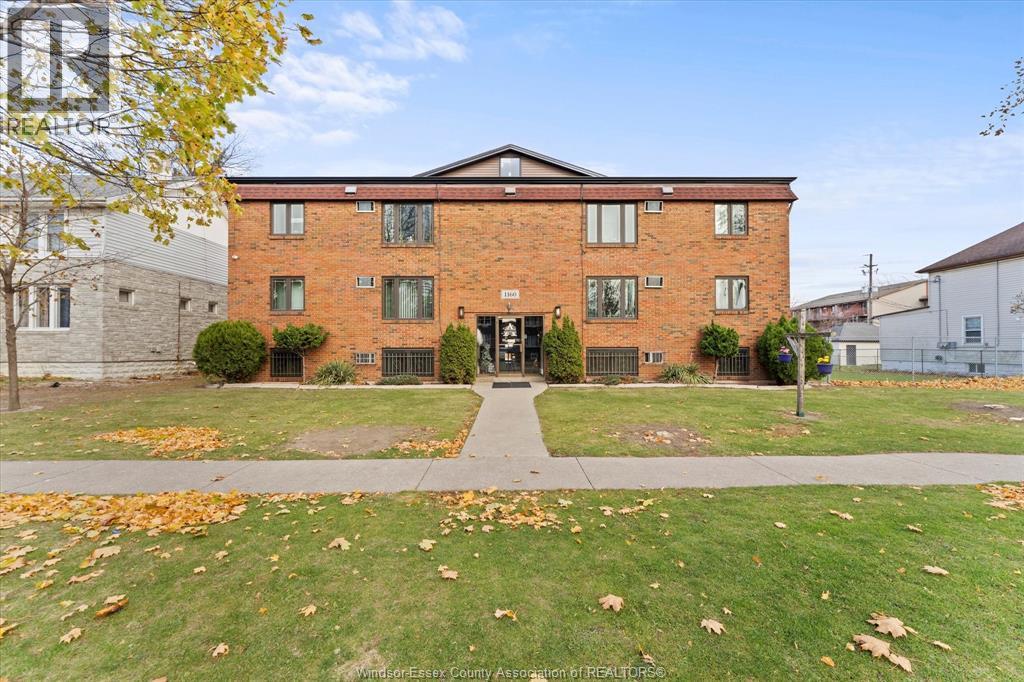 A brick building with a green lawn in front.