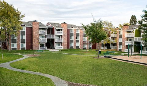 an apartment building with a park in front of it